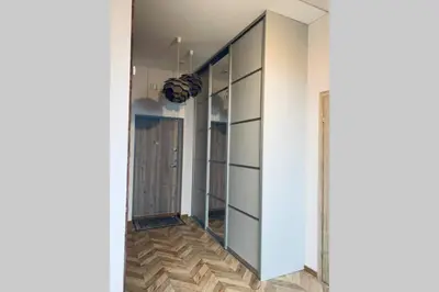 a hallway with glass doors and wood floors at Botanical Manor Apartment in Kaunas