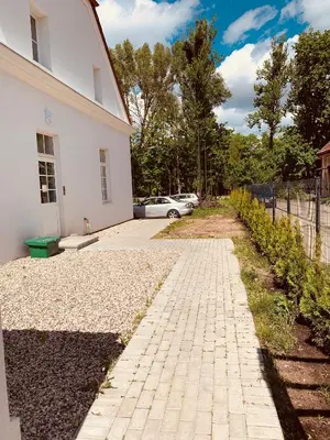 a brick sidewalk next to a white building at Botanical Manor Apartment in Kaunas