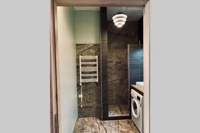 a bathroom with a sink and a washing machine at Botanical Manor Apartment in Kaunas