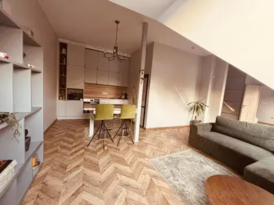 a living room with a couch and a table at Botanical Manor Apartment in Kaunas
