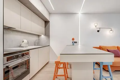 a kitchen with white cabinets and a table and chairs at HaPPy Inn G, Self check-in, Terrace, Underground Parking in Vilnius