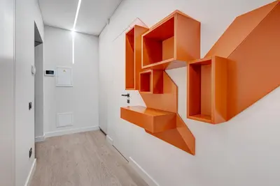 a room with orange shelves on the wall at HaPPy Inn G, Self check-in, Terrace, Underground Parking in Vilnius