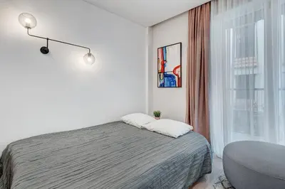 a white bedroom with a bed and a window at HaPPy Inn G, Self check-in, Terrace, Underground Parking in Vilnius
