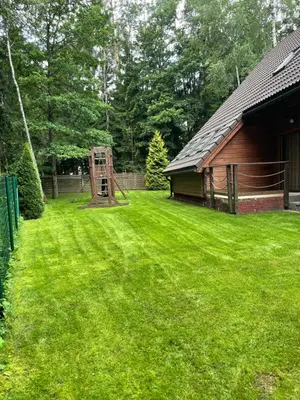 a yard with a playground in front of a house at Rustic private Cabin in woods w/ Sauna & Pool in Vilnius