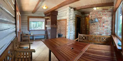 a dining room with a wooden table and chairs at Rustic private Cabin in woods w/ Sauna & Pool in Vilnius