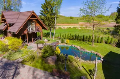 a home with a small pool in the yard at Rustic private Cabin in woods w/ Sauna & Pool in Vilnius