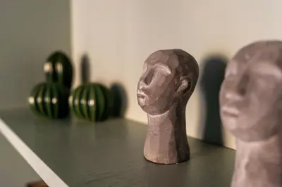 a figurine of a man sitting on a table next to green bowls at Cozy Apartment In Kaunas Center in Kaunas