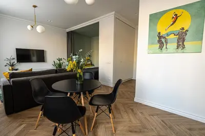 a living room with a couch and a table and chairs at Cozy Apartment In Kaunas Center in Kaunas