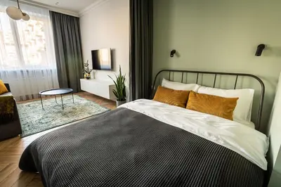 a bedroom with a large bed and a table at Cozy Apartment In Kaunas Center in Kaunas