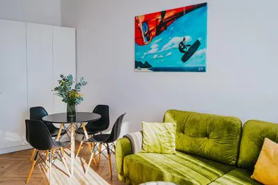a living room with a green couch and a table at Wonderful Apartment In The Heart Of Kaunas Center in Kaunas