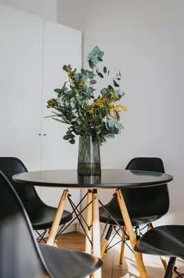 a vase of flowers on a table with chairs at Wonderful Apartment In The Heart Of Kaunas Center in Kaunas