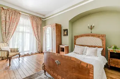 a bedroom with a large bed with a wooden headboard at Taujėnų dvaro svečių namai in Towiany