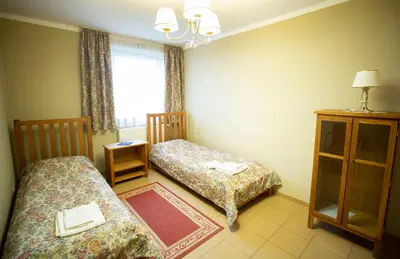 a small room with two beds and a window at Taujėnų dvaro svečių namai in Towiany