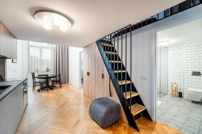 a kitchen and dining room with a staircase in a house at Owl Jazz Apartments - luxury apartments in the heart of the city in Kaunas