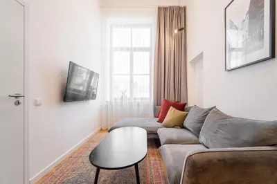 a living room with a couch and a table at Owl Jazz Apartments - luxury apartments in the heart of the city in Kaunas