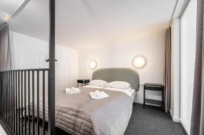 a bedroom with a bed with two towels on it at Owl Jazz Apartments - luxury apartments in the heart of the city in Kaunas