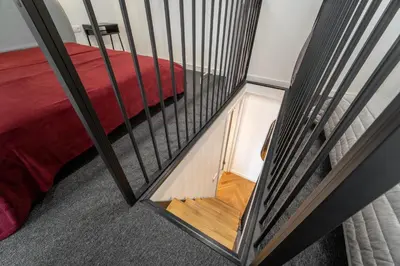 a stairway leading to a room with a red bed at Owl Jazz Apartments - luxury apartments in the heart of the city in Kaunas