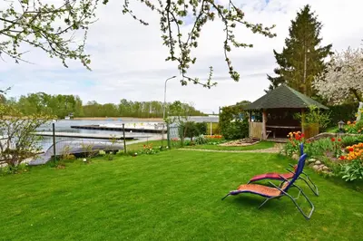 a garden with a bench in the grass at Augutės Zurlienės apartamentai in Trakai