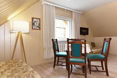 a dining room with a table and chairs and a window at Augutės Zurlienės apartamentai in Trakai