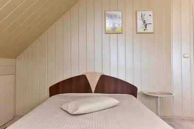 a bed with a wooden headboard in a room at Augutės Zurlienės apartamentai in Trakai