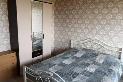 a bedroom with a bed and a dresser in it at Pigūs apartamentai Panevėžyje in Panevėžys