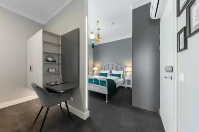a bedroom with a bed and a desk with a chair at Vilnius legends house I Best for families I Free parking in Vilnius