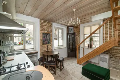 a kitchen with a brick wall and a staircase at St Anne studio in Vilnius