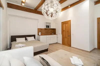 a bedroom with a bed and a chandelier at St Anne studio in Vilnius