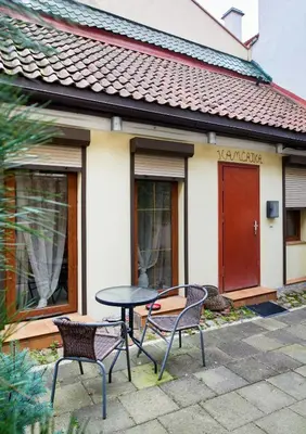 a table and two chairs in front of a house at Old Town Apart FREE Parking in Vilnius