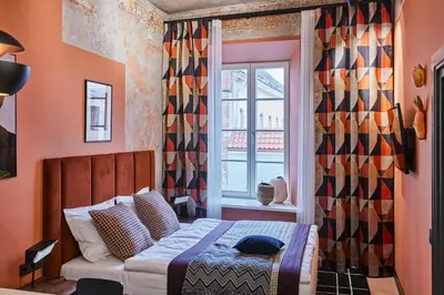 a small bedroom with a bed and a window at ROOMA Apartments Boutique Old Town Self Check-in in Vilnius