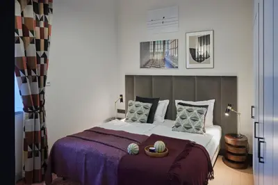 a bedroom with a large bed with a purple blanket at ROOMA Apartments Boutique Old Town Self Check-in in Vilnius