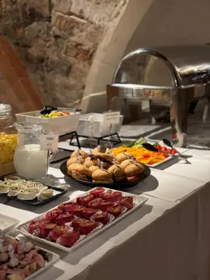 a buffet with many different types of food on a table at ROOMA Apartments Boutique Old Town Self Check-in in Vilnius
