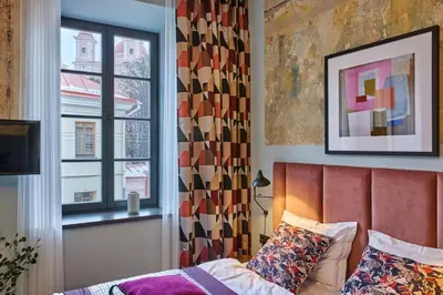 a bedroom with a bed and a window at ROOMA Apartments Boutique Old Town Self Check-in in Vilnius