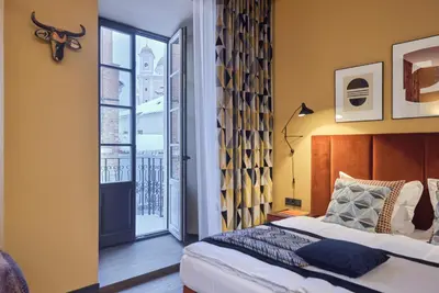 a bedroom with a bed and a large window at ROOMA Apartments Boutique Old Town Self Check-in in Vilnius