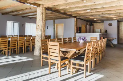 a dining room with a wooden table and chairs at Bilso Sodyba in Vilkanastrai