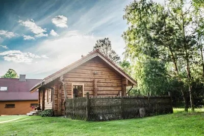 a log cabin with a fence in front of it at Bilso Sodyba in Vilkanastrai