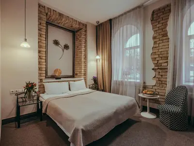 a bedroom with a bed and a brick wall at Moon Garden Old Town Hotel in Vilnius