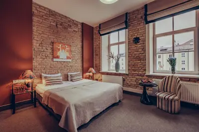 a bedroom with a bed and a brick wall at Moon Garden Old Town Hotel in Vilnius