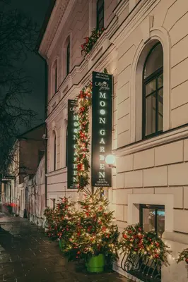a sign on the side of a building with flowering plants at Moon Garden Old Town Hotel in Vilnius