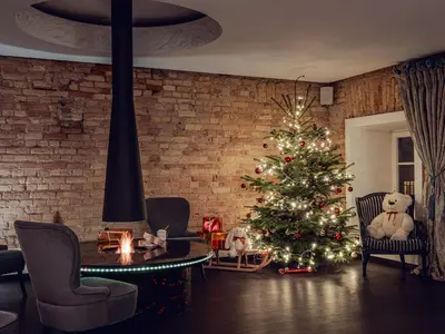 a christmas tree in a living room with a fireplace at Moon Garden Old Town Hotel in Vilnius