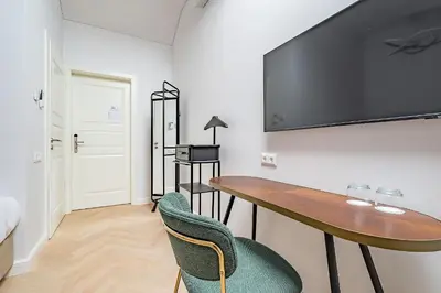 a room with a desk and a tv on a wall at St Casimir Apartments in Vilnius