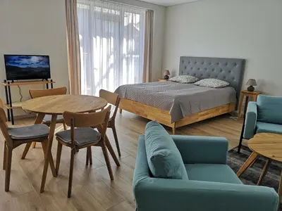 a bedroom with a bed and a table and chairs at Centro apartamentai II in Birštonas