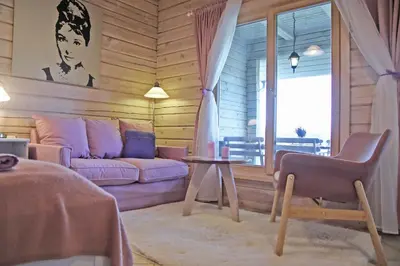 a living room with a purple couch and a table at Lavender Village in Kiemeliai