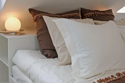a pile of pillows sitting on top of a bed at Lavender Village in Kiemeliai