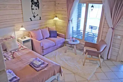 a living room with a bed and a couch at Lavender Village in Kiemeliai