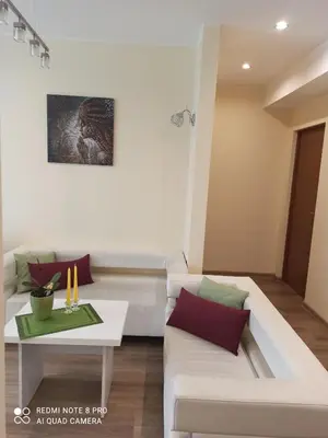 a living room with a white couch and a table at Nelli apartamentai in Druskininkai