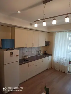 a kitchen with white cabinets and a white refrigerator at Nelli apartamentai in Druskininkai