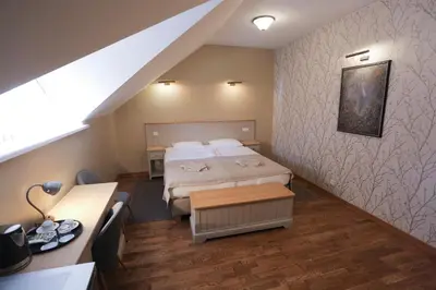 a small room with two beds and a staircase at Hotel Jonapolis in Jonava