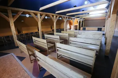 a row of wooden benches in a room at Hotel Jonapolis in Jonava