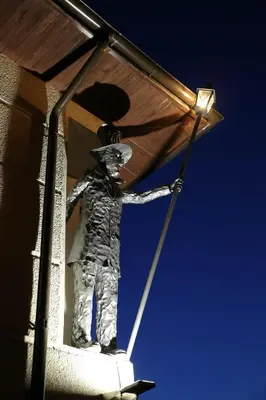 a statue of a man holding a light on a building at Hotel Jonapolis in Jonava